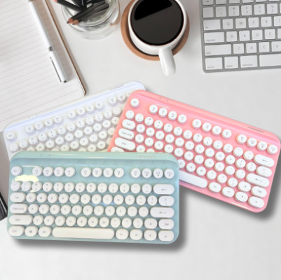 Un clavier sas fil rose et bleu sur unhe table de bureau