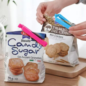 Une femme qui ferme des sachats en plastique avec des clips d'étachéité.